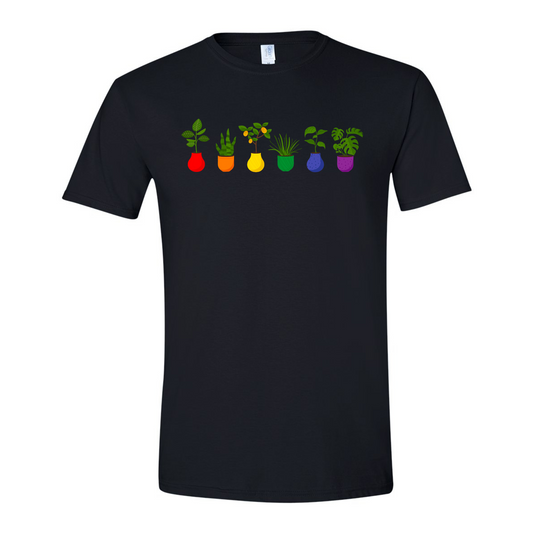 Pictured is a shirt in black that has six potted plants across the chest. The first plant is a leafy tall plant in a red vase, the second is a snake plant in an orange vase, the third is a lemon tree in a yellow vase, the fourth is a spiky looking plant in a green vase, the fifth is another tall leafy looking plant in a blue vase, and the fifth is a monstera in a purple vase.